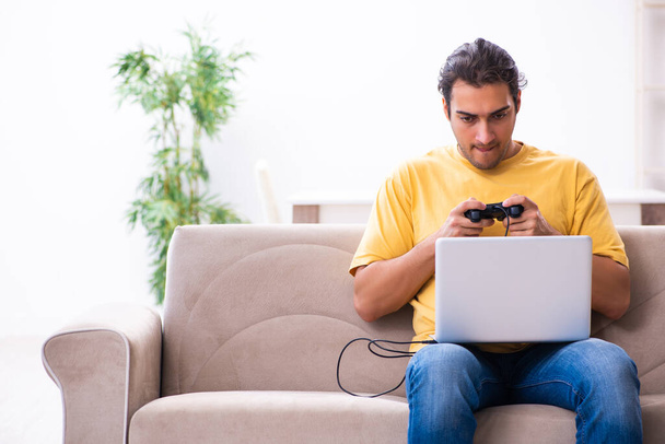 Fiatal férfi játszik joystick játékok otthon - Fotó, kép
