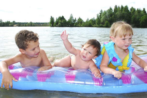 a riverchildren úszó egy gumimatrac nyár. - Fotó, kép