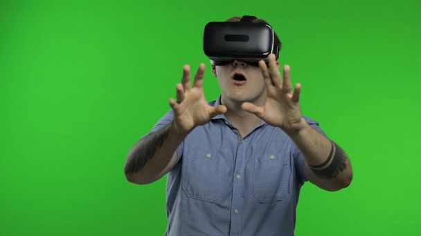Ο άνθρωπος που χρησιμοποιεί κράνος VR app για να παίξει παιχνίδι προσομοίωσης, σχέδιο. Guy βλέποντας εικονική πραγματικότητα 3d βίντεο - Φωτογραφία, εικόνα