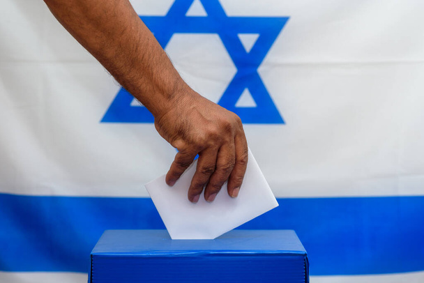 Izraelczyk oddaje głos do urny wyborczej w dniu wyborów. - Zdjęcie, obraz