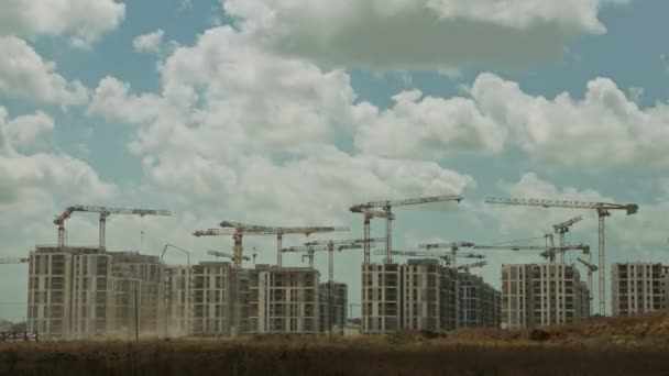 Timelapse de un gran sitio de construcción con muchas grúas trabajando sobre edificios - Metraje, vídeo