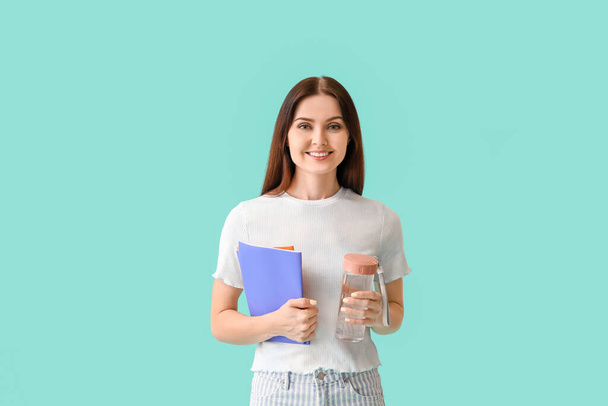 Young woman with bottle of water on color background - Photo, Image