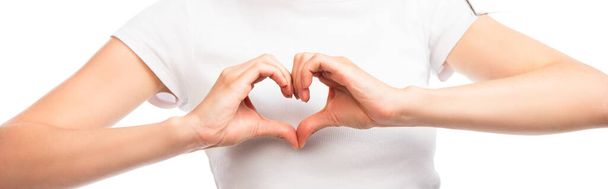 cultivo panorámico de la mujer que muestra el signo del corazón con las manos aisladas en blanco - Foto, imagen
