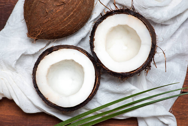 Gehalveerd open kokosfruit op een houten tafelblad - Foto, afbeelding
