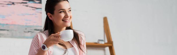 horizontal crop of woman looking away while holding cup of coffee - Foto, Imagem