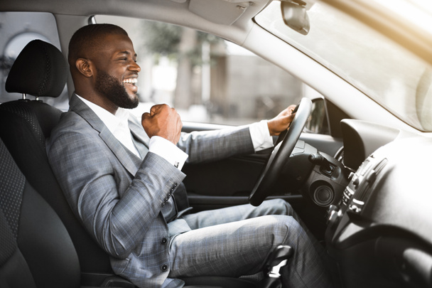 Jeune homme d'affaires noir émotionnel conduire après réunion d'affaires réussie - Photo, image