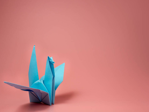Paper origami dove of peace on a pink background. - Foto, imagen