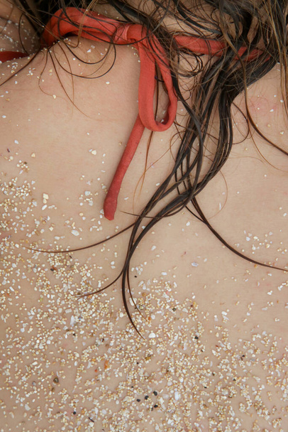 ビーチでの女性の髪、肌に砂やぬれた髪の画像を閉じます。塩辛い海の水と太陽、夏の時間のヘアケアの概念による髪の損傷.  - 写真・画像