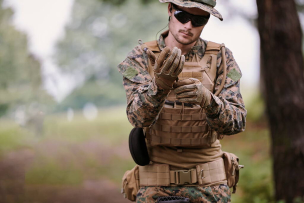 american  marine corps special operations soldier preparing tactical and commpunication gear for action battle closeup - Фото, зображення