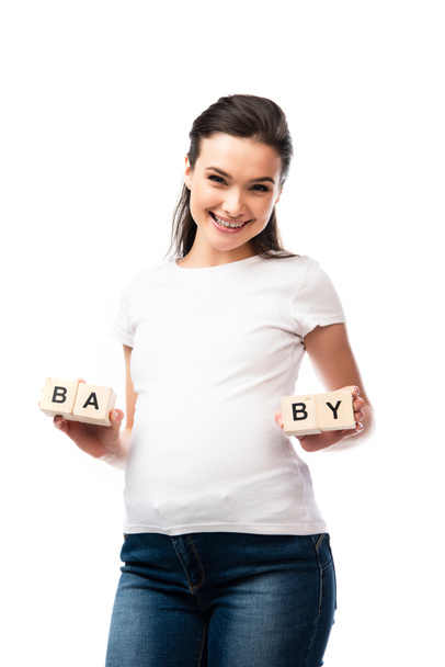 jeune femme enceinte en t-shirt blanc tenant des cubes en bois avec lettrage bébé isolé sur blanc  - Photo, image