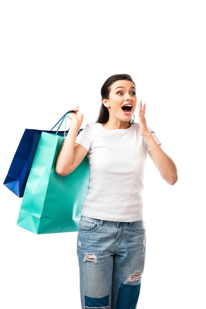 surprised woman holding shopping bags isolated on white  - Фото, зображення