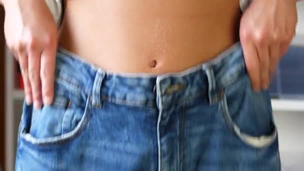 女性は体重を減らし、大きな青いジーンズが落ちる - 映像、動画