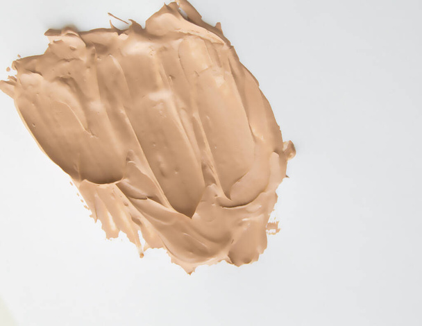 Foundation cream for makeup, make-up concept, smeared cosmetic cream on a white background. - Valokuva, kuva