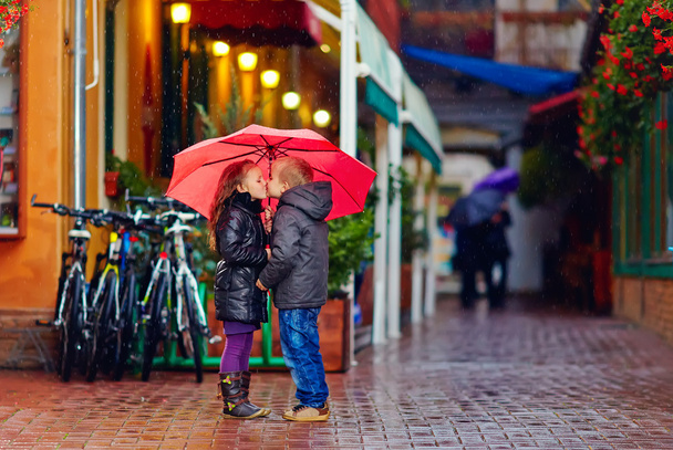 cute young couple kissing under the rain - Foto, afbeelding