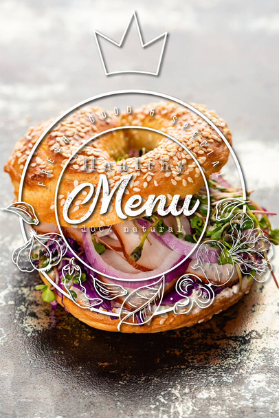fresh bagel with meat, red onion, cream cheese and sprouts near healthy menu lettering on textured grey surface - Photo, Image