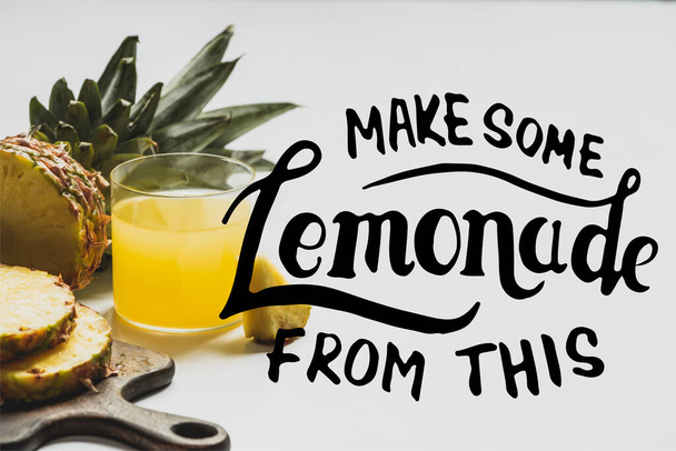 fresh pineapple juice near sliced fruit on wooden cutting board near make some lemonade from this lettering on white  - Photo, Image