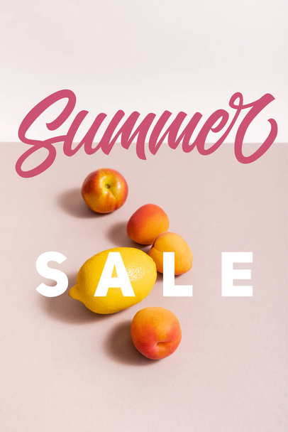 fruit composition with lemon and apricots near summer sale lettering on beige and white - Foto, Imagem
