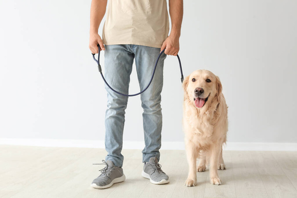 Young man with cute dog indoors - Фото, зображення