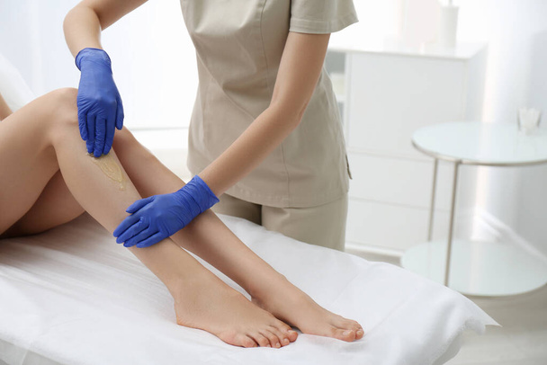 Woman getting wax epilation of legs in salon, closeup - Fotografie, Obrázek