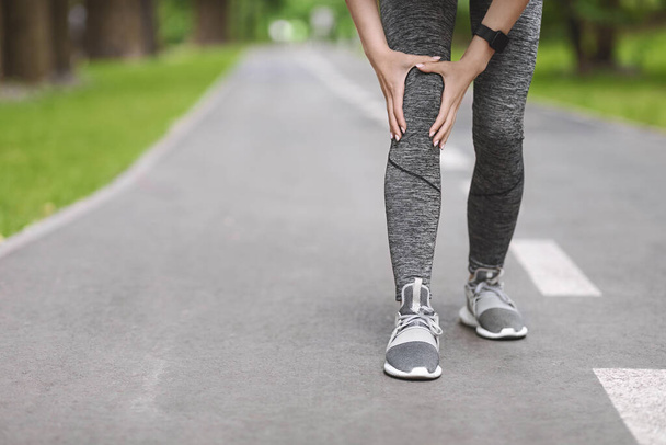 Knee Trauma. Unrecognizable Woman Jogger Hut Her Leg During Running Outdoors - Foto, imagen