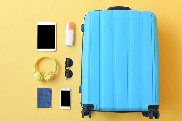 色の背景にビーチアクセサリーやデバイス付きのパックされたスーツケース。旅行のコンセプト - 写真・画像
