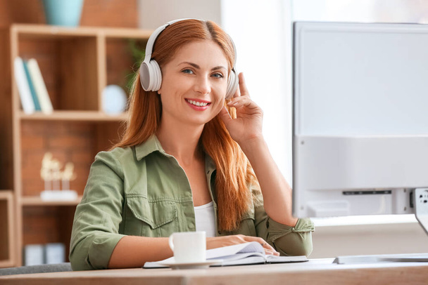 Woman with headphones working in office - Foto, Imagen