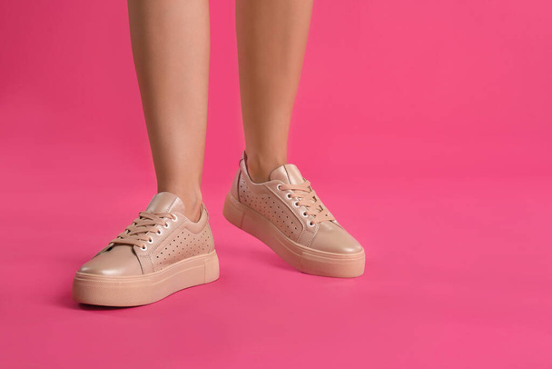 Woman wearing shoes on pink background, closeup - 写真・画像