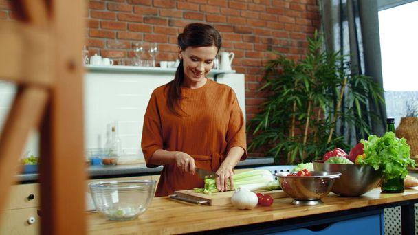 Žena krájí zeleninu na salát v kuchyni. Žena v domácnosti vaří zdravé jídlo. - Fotografie, Obrázek