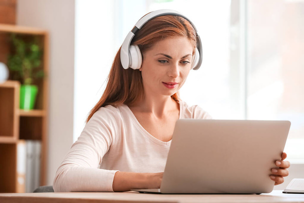 Woman with headphones working in office - Foto, Imagem