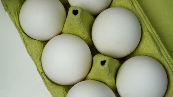 Kuchaři ruku v gumových ochranných rukavicích vzít dvě bílá kuřecí vejce z kartónové podnos vejce na vaření snídaně. Domácí kuchyně. Detailní záběr. - Záběry, video