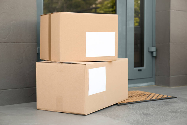 Cardboard boxes near door. Parcel delivery service - Фото, зображення