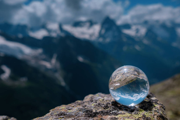 όμορφη σφαιρική γυάλινη μπάλα με μεγαλοπρεπή βουνά Καυκάσια, Dombai, Ρωσία. η ιδέα και η έννοια της ανακάλυψης, ταξίδια και πεζοπορία, Πεζοπορία θέμα. - Φωτογραφία, εικόνα