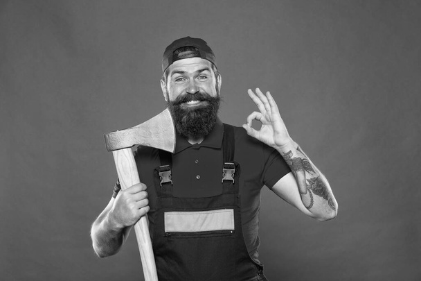 forester hold the ax. man in uniform cut beard hair with ax. brutal bearded man use axe. Hike vacation. Brave enough. better use blade in barbershop. Brutal and bearded. man show ok gesture - Fotoğraf, Görsel