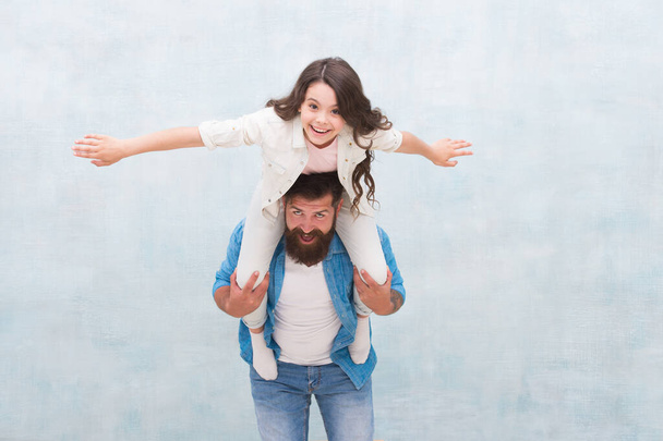 I believe I can fly. Happy father piggyback little daughter. Bearded man and small child play together. Having fun. Active games. Sharing trust relations. Family trust and love. Family values - Valokuva, kuva