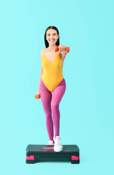 Jeune femme faisant de l'aérobic sur fond de couleur - Photo, image