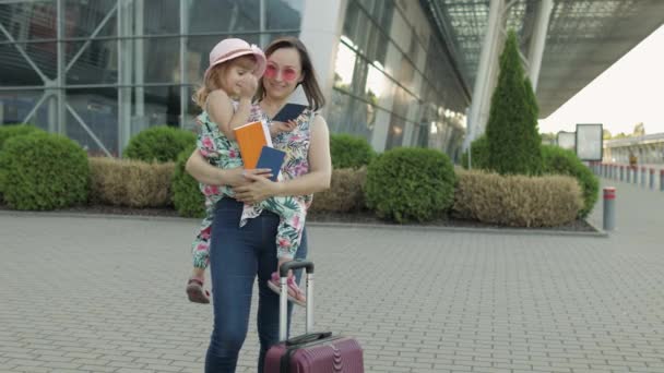 Mutter und Tochter in Flughafennähe. Frau hält Pässe und Fahrkarten in der Hand. Urlaub für Kind und Mutter - Filmmaterial, Video