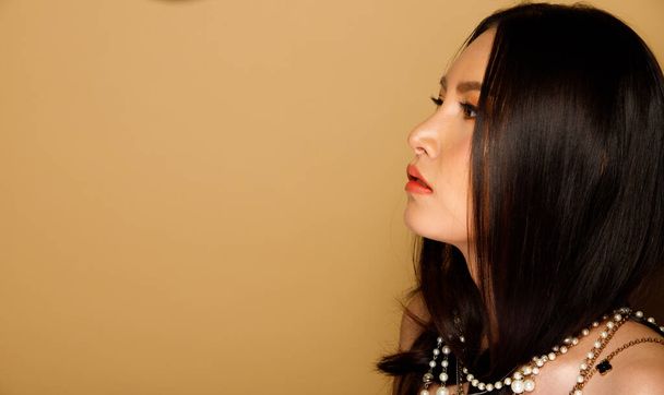 Portrait de mode 20s femme asiatique a belle mise à jour maquillage artiste sur pinceau et rouge à lèvres de couleur, il porte des articles à la mode, cheveux noirs regarder la caméra sur fond jaune isolé espace de copie - Photo, image