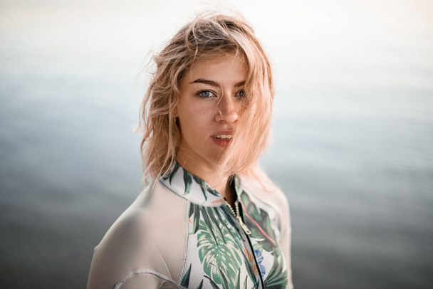 portrait of young beautiful blonde woman with wet hair in gray wetsuit - Foto, Imagem