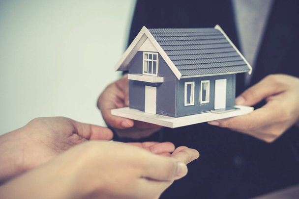 Prodejce domů nebo realitní makléř obdrží dům pro zákazníka, který podepíše kupní smlouvu na bydlení, vyjednání koncepce nákupu-prodeje a investičního plánování. - Fotografie, Obrázek