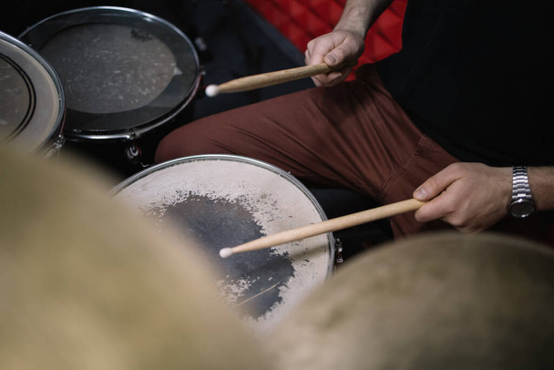 Side view of cropped drummer playing drums with sticks - Foto, imagen