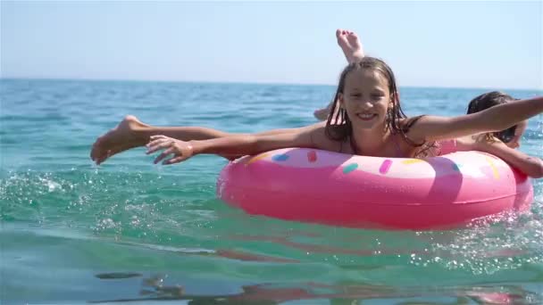 Küçük kızlar yaz tatilinde tropik plajda eğleniyorlar. Birlikte oynuyorlar. - Video, Çekim