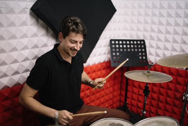 Young attractive man drummer playing drums and cymbals - Foto, Imagen