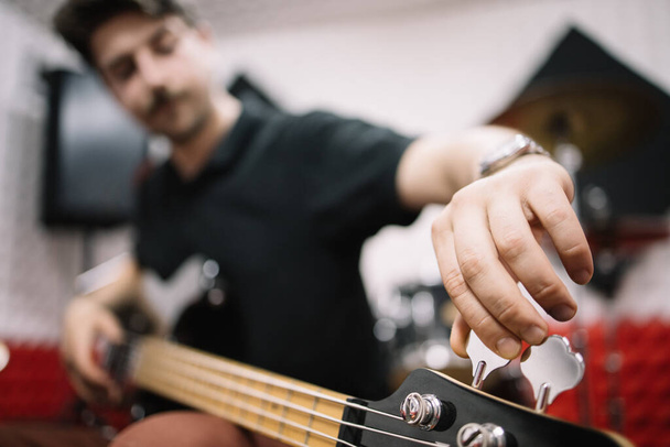 Blurred male musician tuning his electric guitar - Φωτογραφία, εικόνα