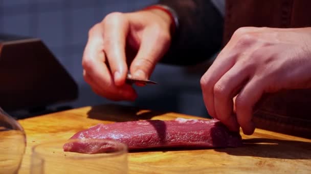 Restaurace kuchyně - kuchař krájení masa v malých plátcích s broušeným nožem na stole - Záběry, video