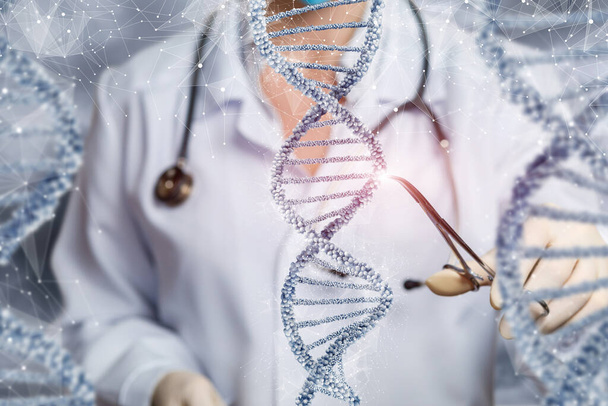 Le médecin examine la molécule d'ADN avec une pince sur un fond flou. - Photo, image