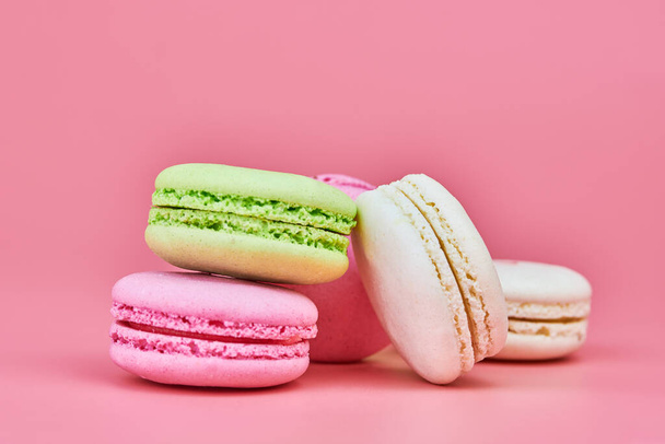 Macaroons on pink background. Colorful small cookie from ground almonds and coconut. Popular confectionery. Tasty snack food for take away, copy space - Foto, Imagen