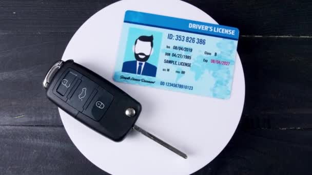 Водійські права і ключ автомобіля на темному дерев'яному фоні, вид зверху
 - Кадри, відео