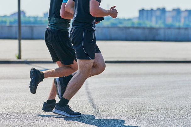 Running men. Sport men jogging in sportswear on city road. Healthy lifestyle, fitness hobby. Street marathon race, sprinting outdoor - Photo, Image