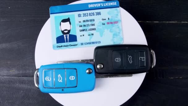 Licencia de conducir y llaves del coche sobre fondo de madera oscura, vista superior - Imágenes, Vídeo