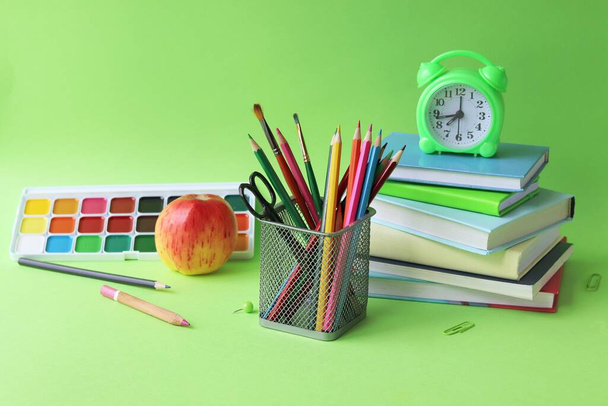 Back to school, stationery, books, alarm clock on bright background, home learning concept, preparation for study - Photo, Image